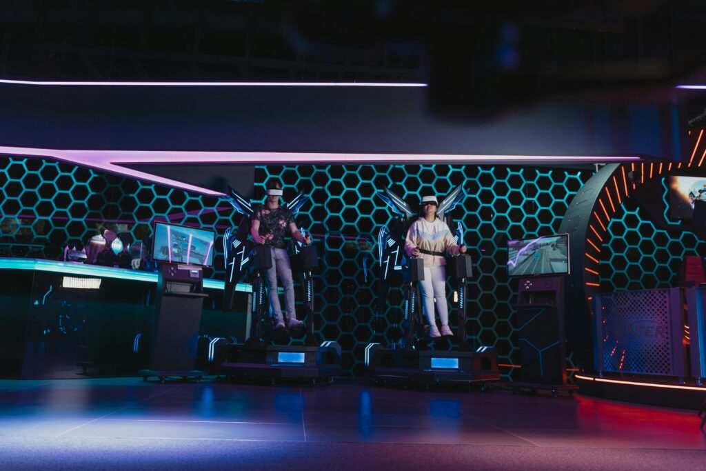 Two people immersed in an interactive VR gaming experience at a modern arcade.